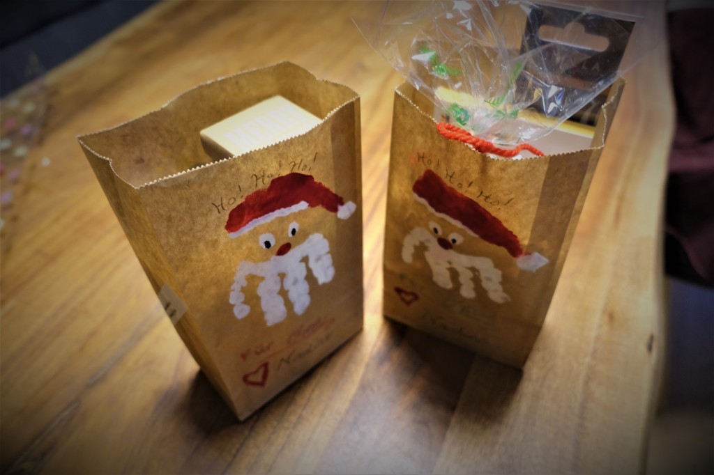 A paper bags with a Santa handprint and footprint